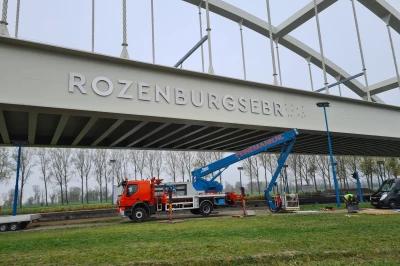 RVS brugletters Hoekman RVS op zijkant spoorbrug bevestigd.